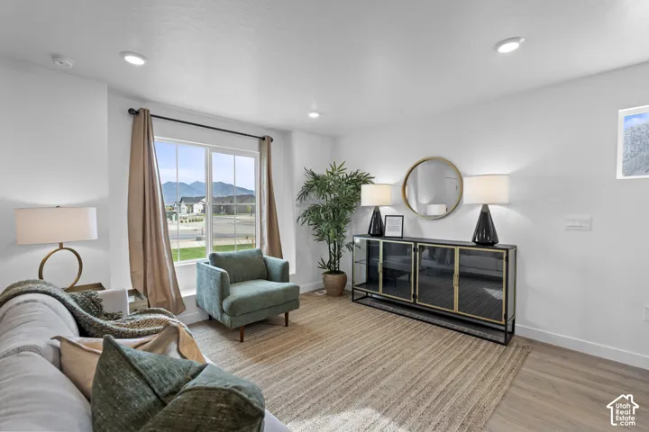 Neutral-toned interior space featuring wood-finish flooring, recessed lighting, and a large window providing a mountain backdrop