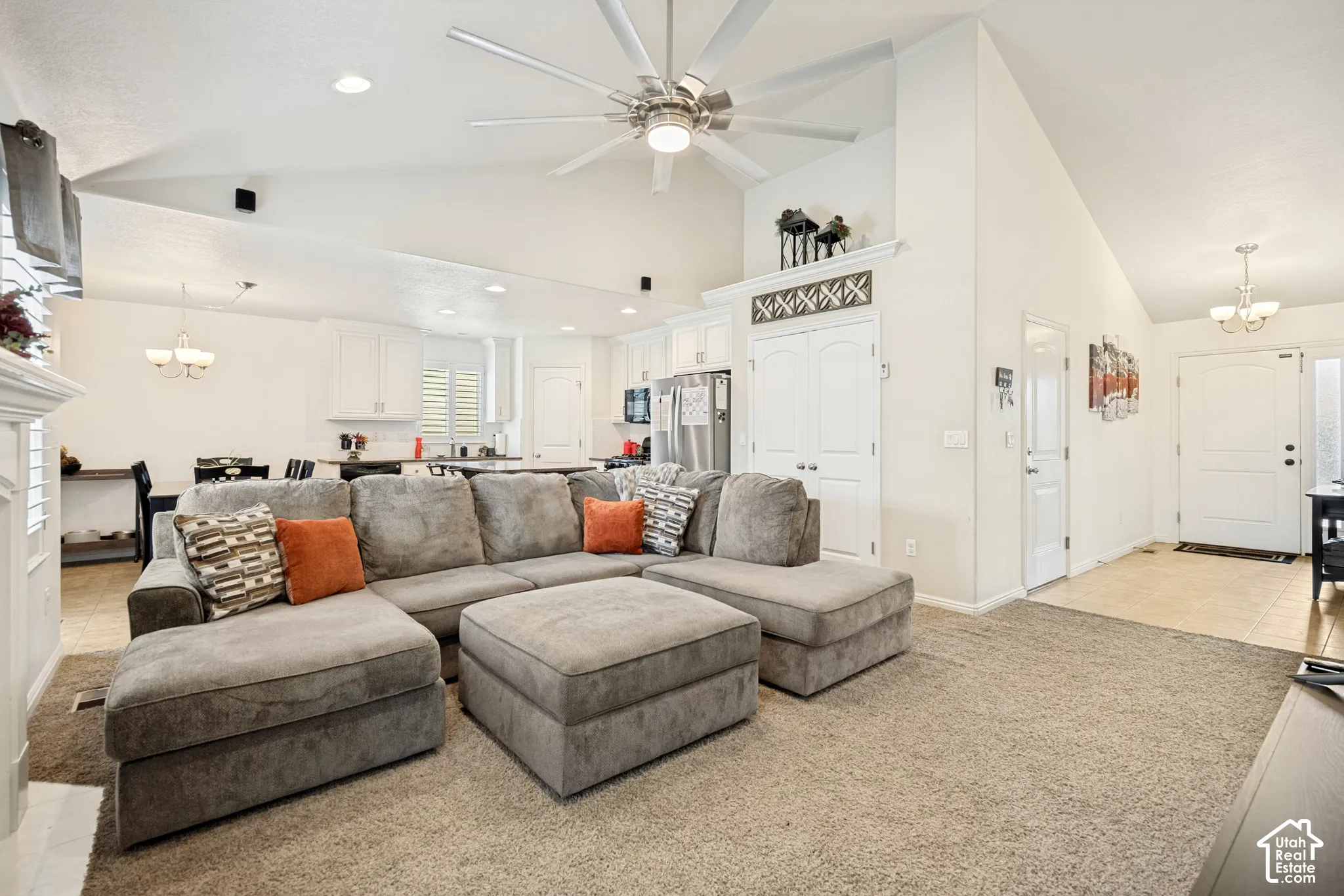 Vaulted ceilings featuring a multi-blade ceiling fan, recessed lighting, white cabinetry, and tile flooring