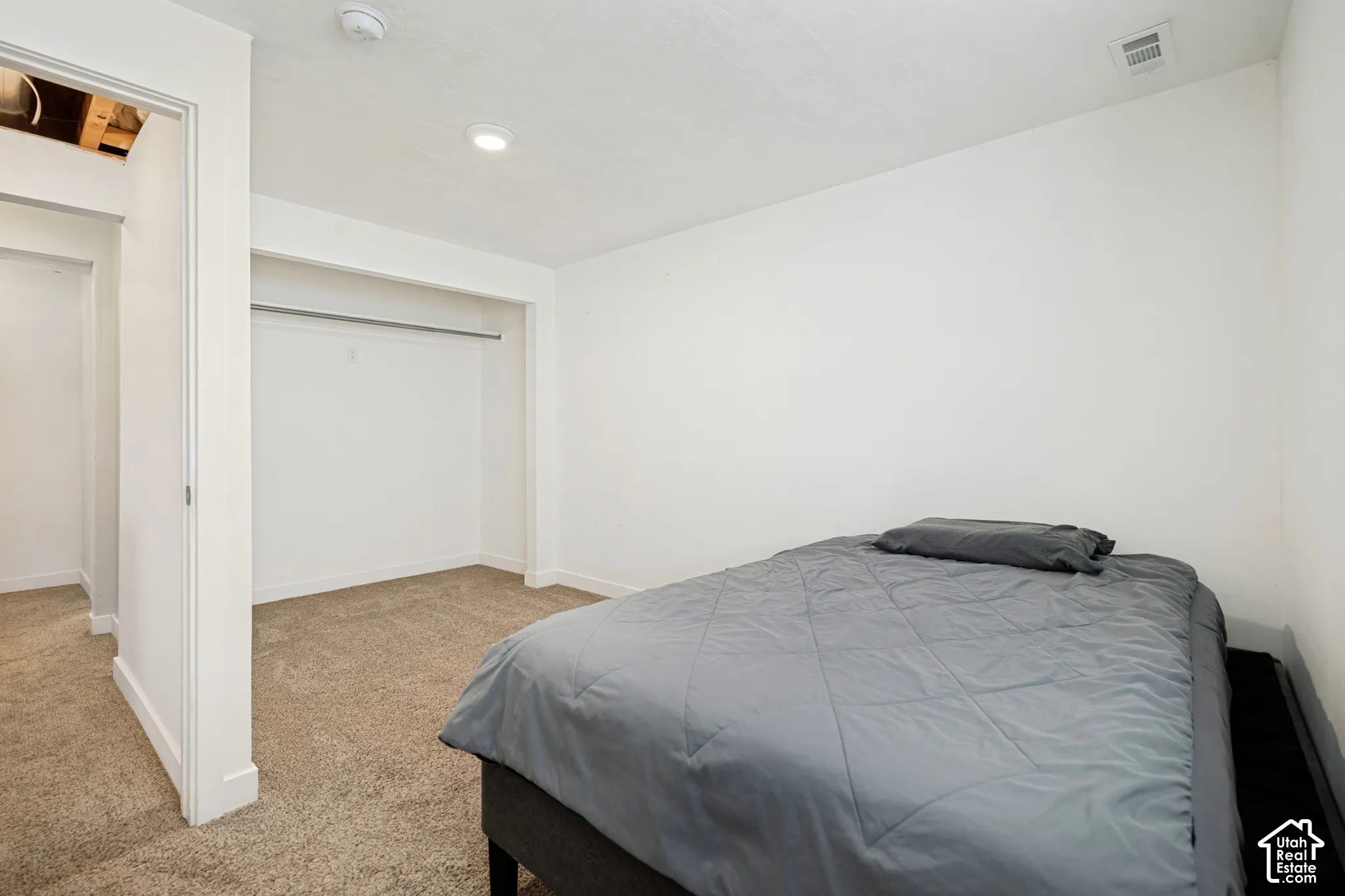Room featuring neutral wall finishes, recessed lighting, carpeted flooring, and a built-in closet with a metal hanging rod