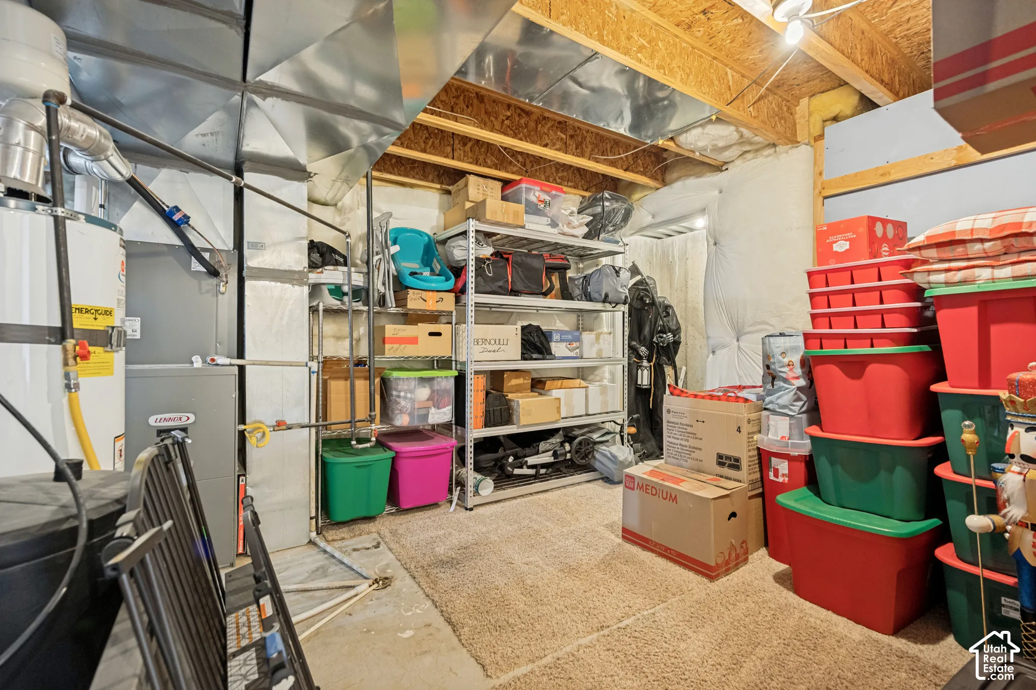 Utility space featuring exposed ceiling joists, a water heater, a high-efficiency furnace, and insulated wall panels