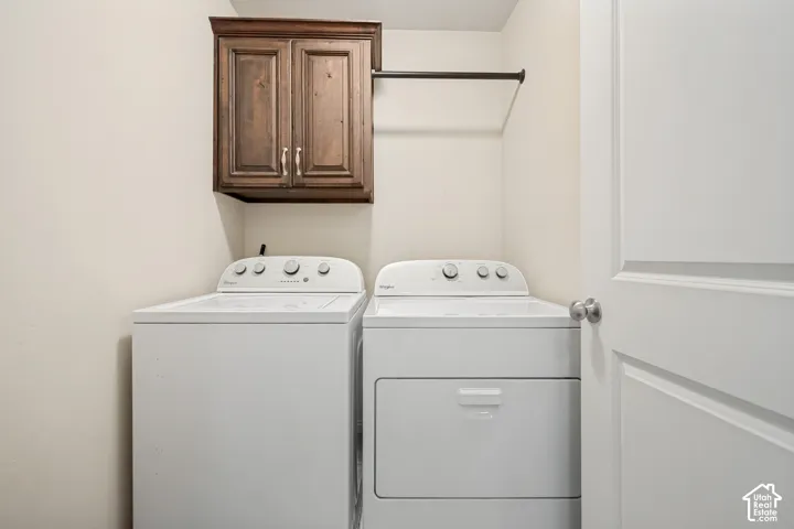 Laundry area featuring dark wood-finish wall cabinetry and a metal hanging rod
