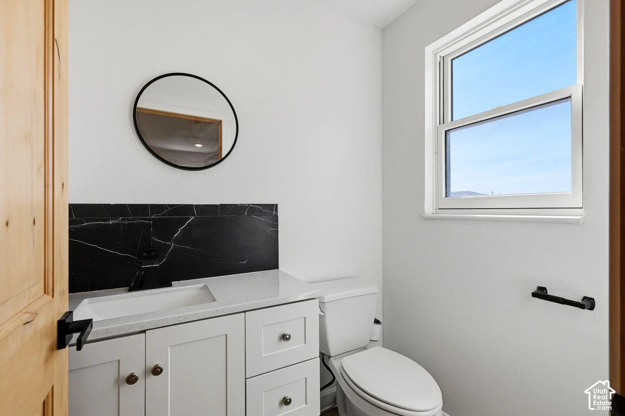 White vanity with a light-toned countertop and an integrated sink