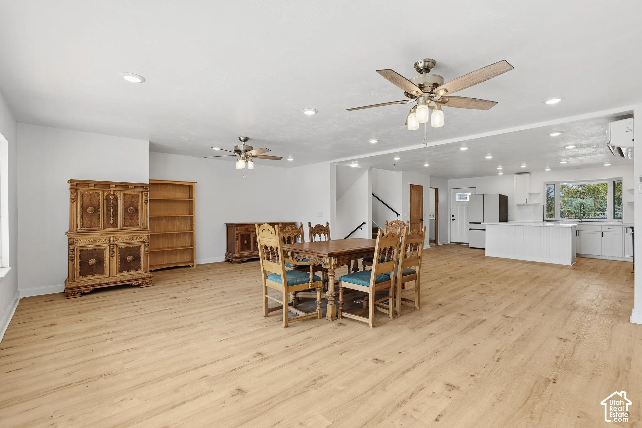 Recessed lighting, wood-finish flooring, white walls, and dual ceiling fans