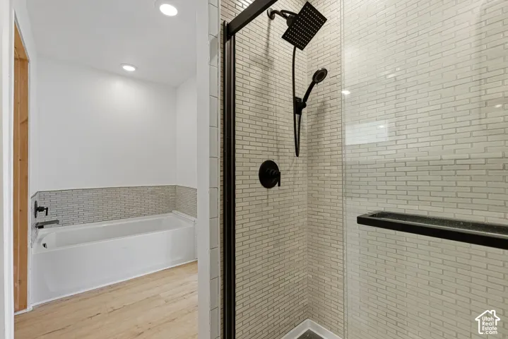 Glass-enclosed shower with matte black fixtures and subway tile