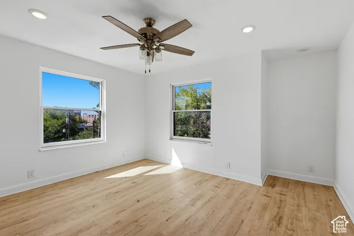 Wood-finish flooring, two window openings, ceiling fan, and recessed lighting