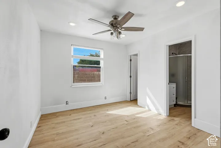Light wood-finish flooring with white walls and recessed ceiling lighting