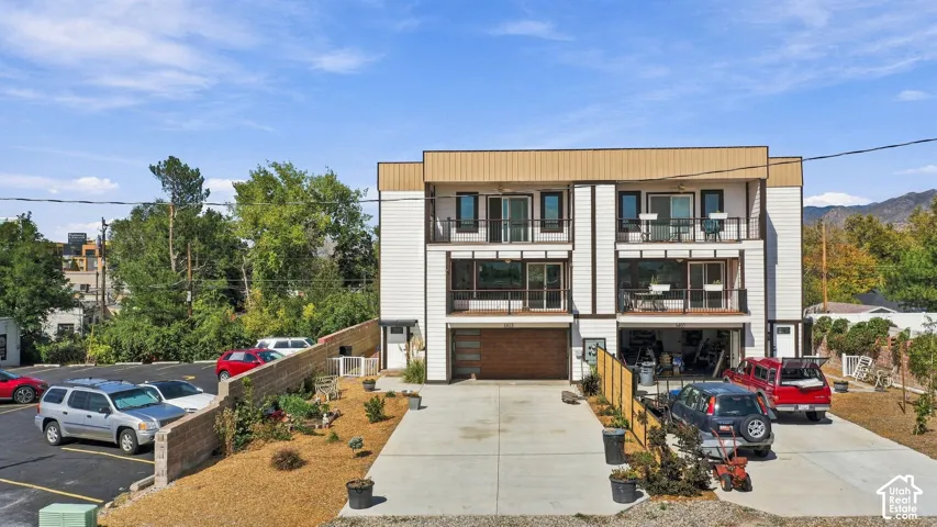 Contemporary multi-level exterior with multiple balconies, a two-car garage, and a concrete driveway