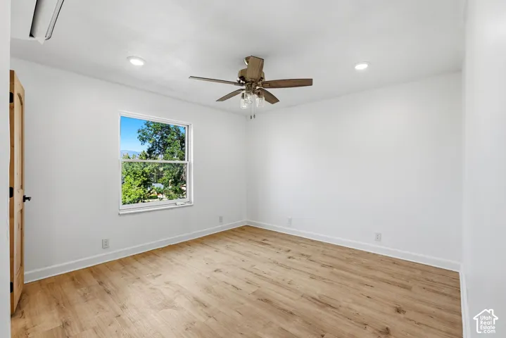 Wood-finish flooring, white walls, and a window providing an expansive outdoor scene