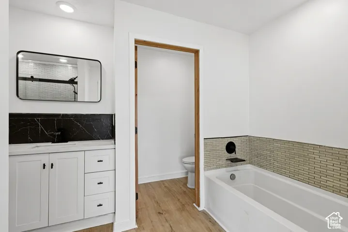 White vanity with black hardware, black marble-look backsplash, white countertop, and rectangular black-framed mirror