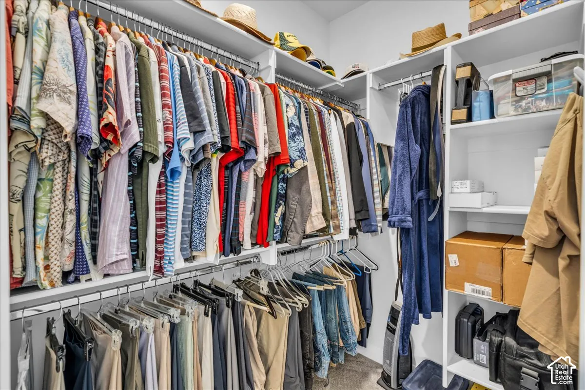 Customized walk-in closet featuring multi-level hanging rods and built-in shelving units