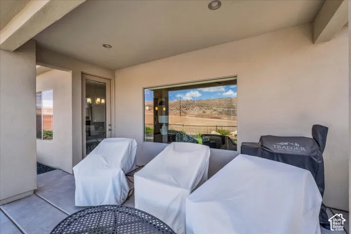 Covered patio featuring concrete flooring, recessed lighting, and a large picture window