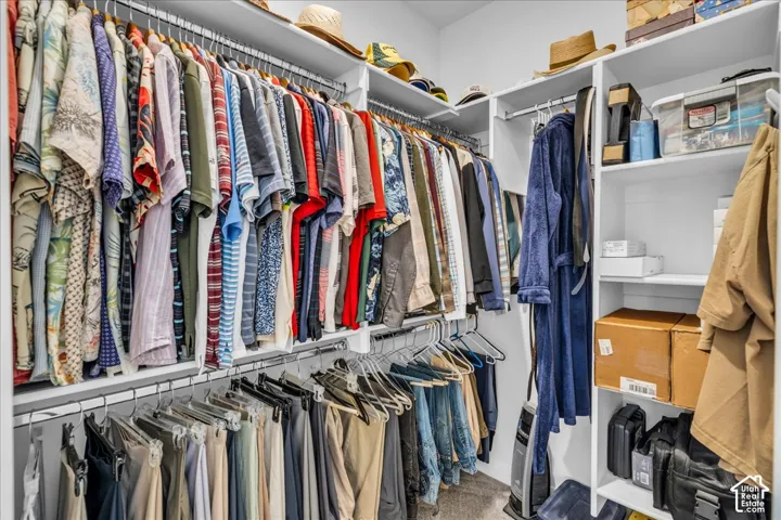 Customized walk-in closet featuring multi-level hanging rods and built-in shelving units