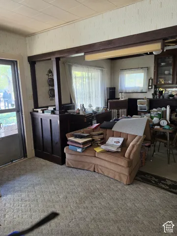 Interior space featuring dark-stained wood half-walls, structural support posts, and built-in glass-front cabinetry