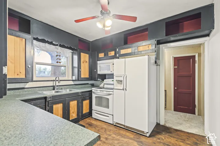 Kitchen featuring custom cabinetry with natural wood-finish door panels, dark-tone accent trim, high-level integrated storage compartments, wood-finish flooring, and a stainless steel arched-neck faucet