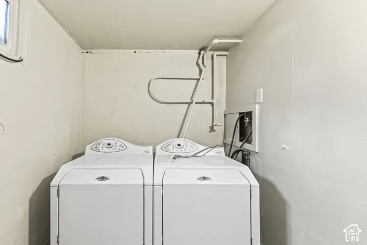 Utility area featuring dedicated laundry hookups, exposed plumbing lines, and an electrical outlet