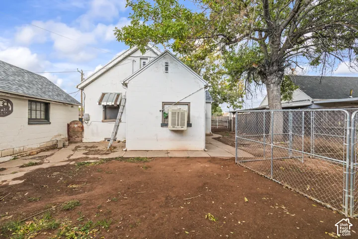 Exterior brick siding, concrete pathways, mature tree coverage, and metal chain-link fencing