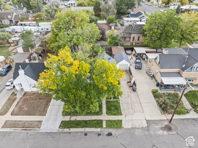 Aerial perspective featuring a detached garage, concrete driveway, and established trees on the property