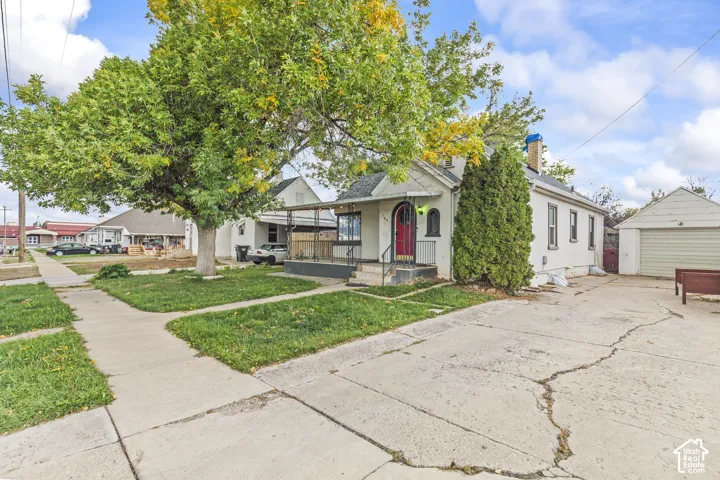 Single-story residence featuring an arched front entryway, covered porch, exterior masonry construction, and a detached garage