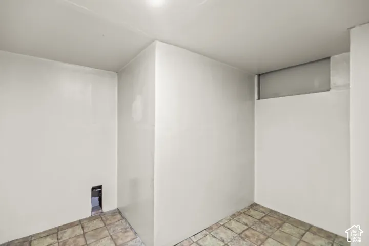 Neutral-toned walls, high-set rectangular window, and tile flooring