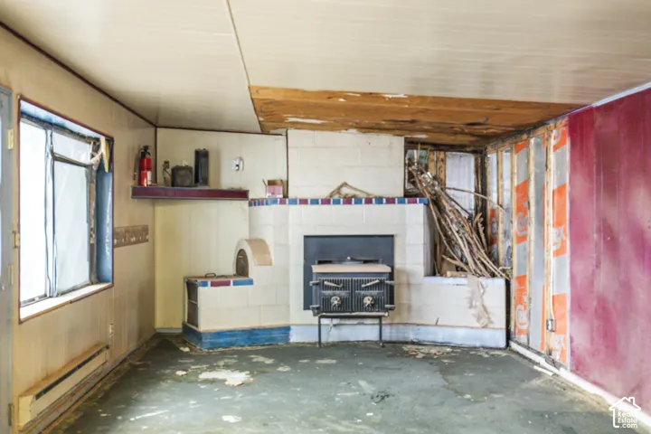 Tiled masonry fireplace featuring a built-in oven and a black cast-iron wood stove