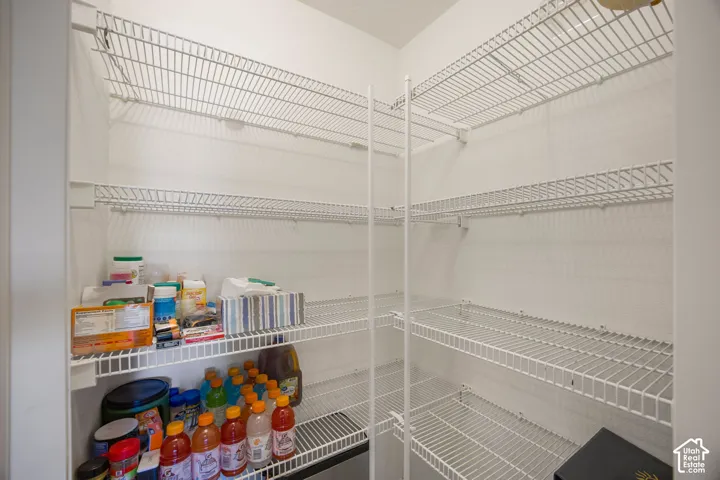 Storage closet featuring white wire shelving units and wall-mounted support brackets