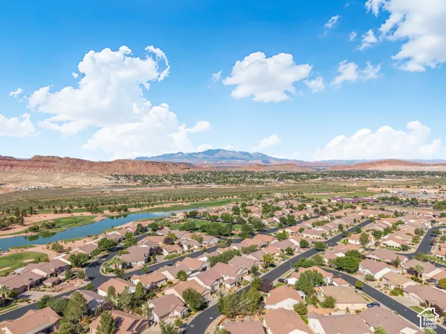 Aerial perspective featuring a desert landscape, mountain backdrop, and expansive green space