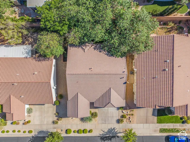 Aerial perspective featuring a tile roof, concrete driveway, and mature landscaping