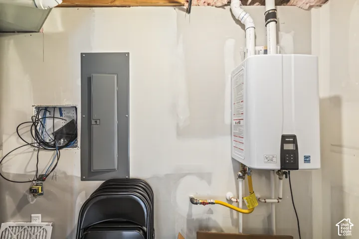 Wall-mounted tankless water heater with digital display and integrated electrical service panel