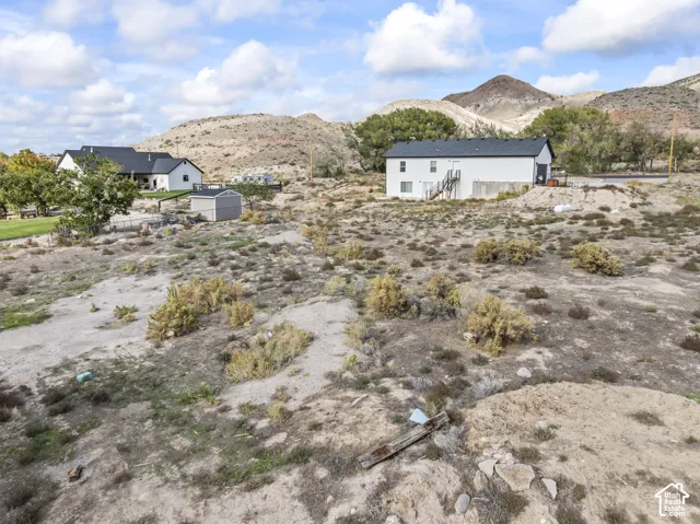 Expansive desert landscape featuring natural rock formations, native vegetation, and mountain backdrop