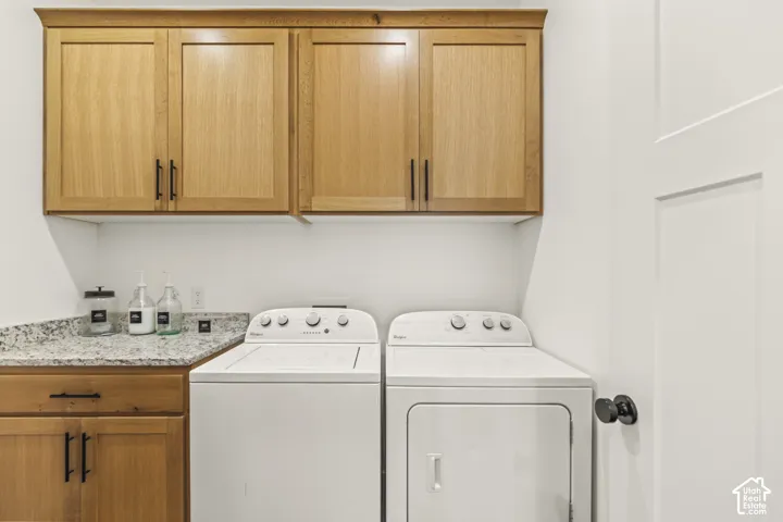 Natural wood-finish cabinetry featuring matte black hardware, stone-patterned countertops, and a shaker-style interior door