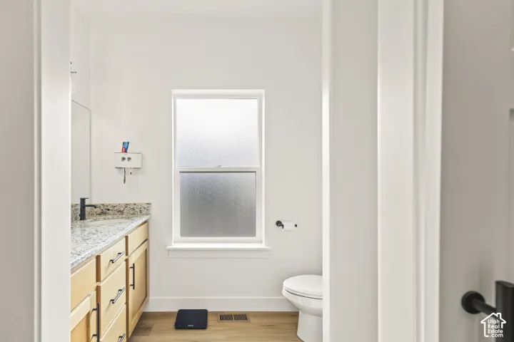 Light-toned cabinetry with matte black hardware, stone-finish countertop, undermount sink with a matte black faucet, and frosted-glass window