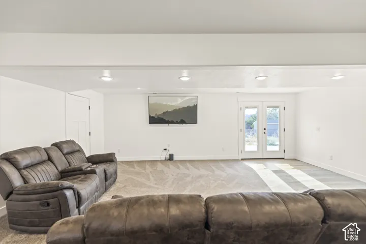 Open interior space featuring recessed ceiling lighting, wall-to-wall carpeting, and double glass-paned doors providing exterior access