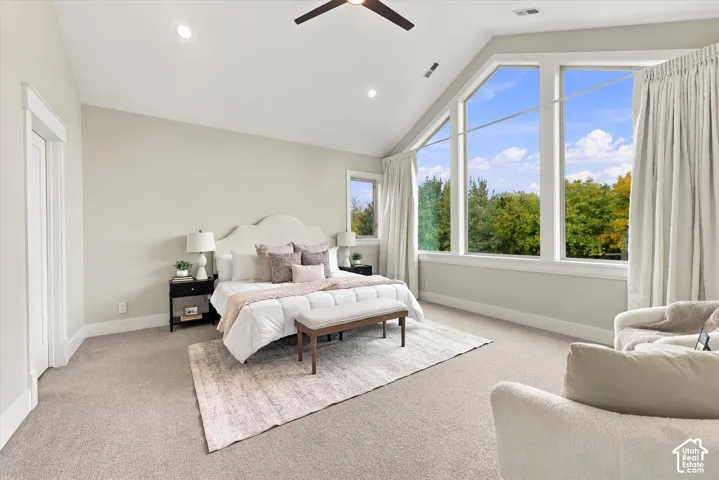 Vaulted ceilings, expansive multi-pane windows, recessed lighting, and a ceiling fan