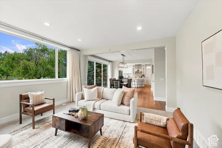 Open-concept living space featuring recessed lighting, large-scale picture windows, sliding glass doors, and wood-finish flooring