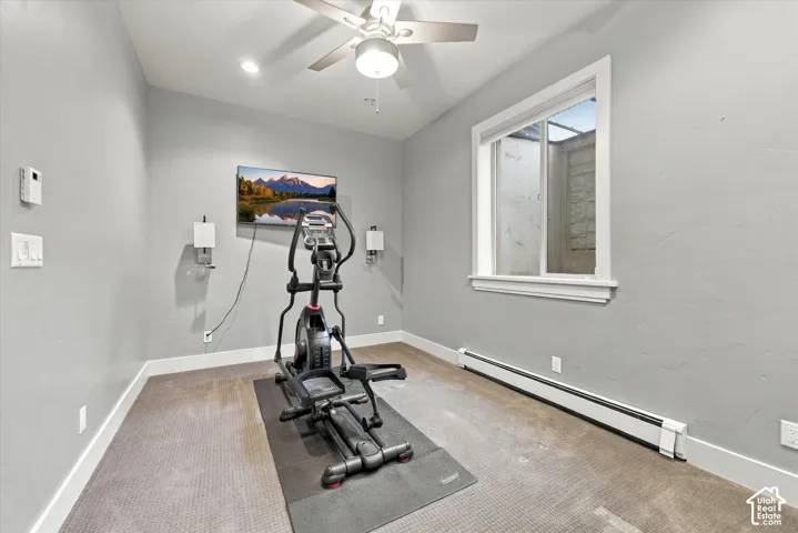 Neutral-toned room featuring a ceiling fan with integrated lighting, wall-mounted light fixtures, and a single-hung window with a sill
