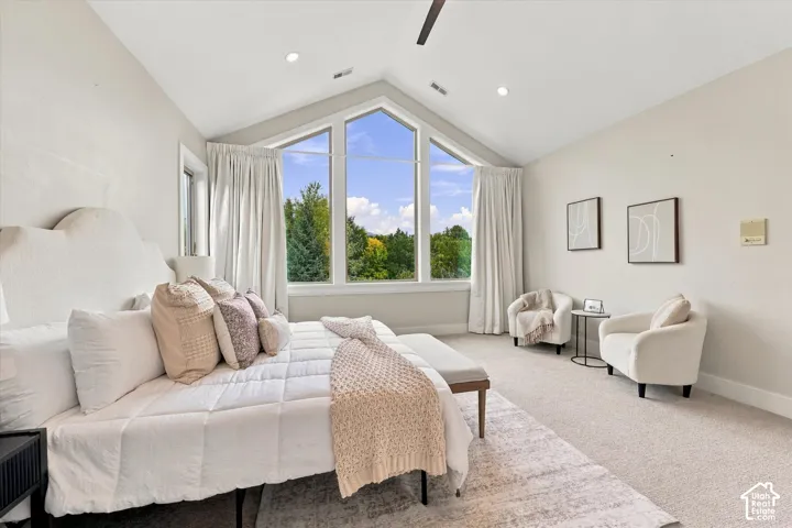 Vaulted ceilings featuring recessed lighting, large picture windows, and neutral carpeting