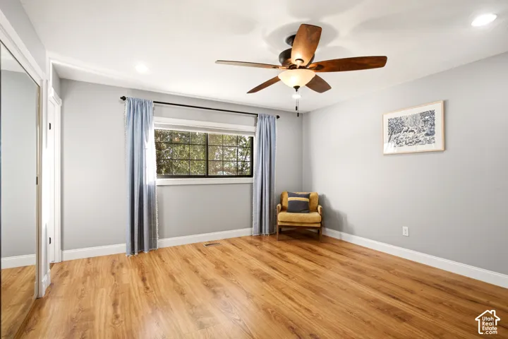 Wood-finish flooring, recessed lighting, multi-pane window, and a ceiling fan with integrated lighting