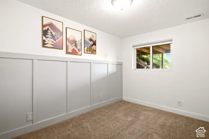 Neutral wall color, gray board-and-batten wainscoting, and carpeting