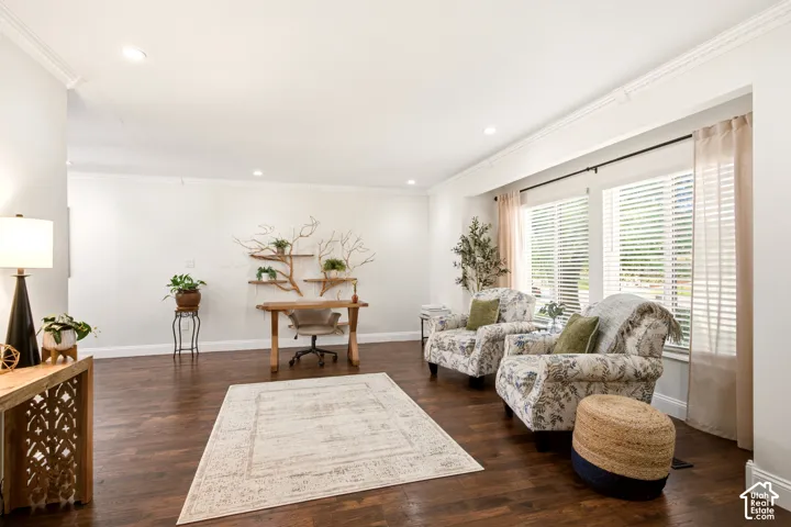 Open living space featuring wood-finish flooring, recessed lighting, crown molding, and large multi-pane windows