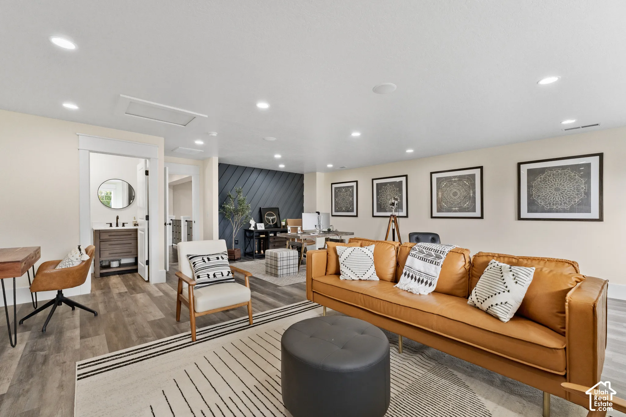Spacious living area featuring wood-finish flooring, recessed lighting, and an accent wall with diagonal paneled detailing