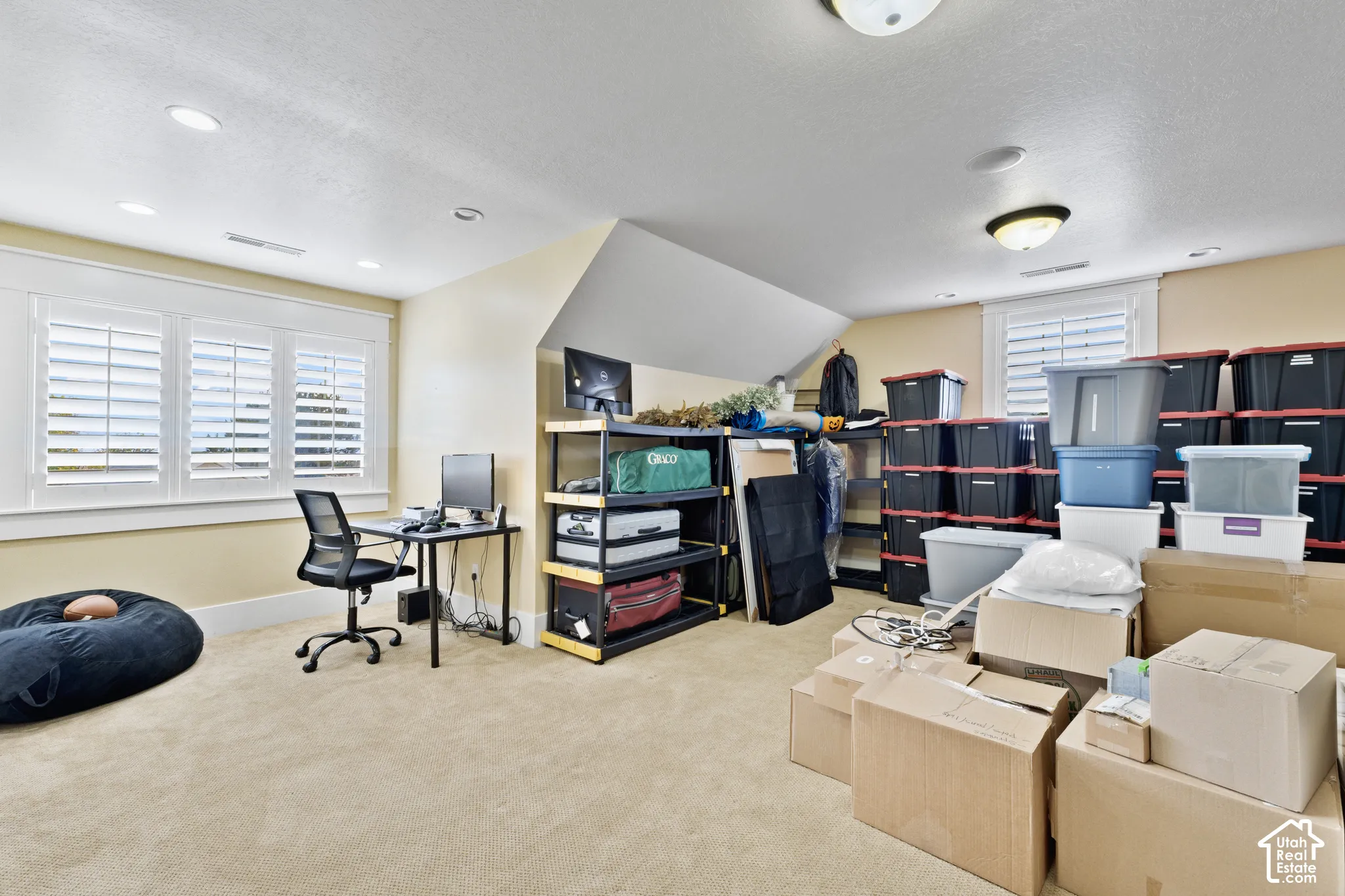 Multi-purpose room featuring neutral carpeting, recessed ceiling lighting, sloped roof lines, and plantation shutters