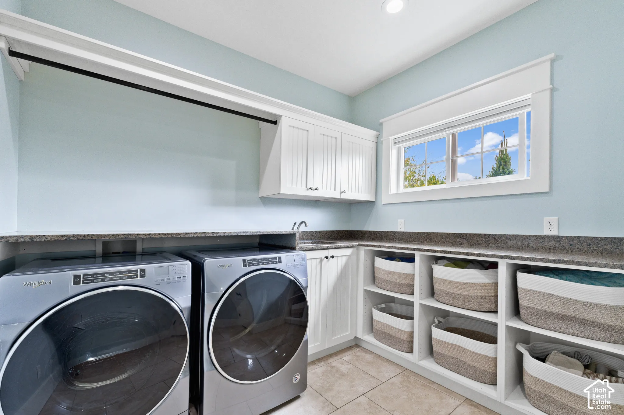 Laundry room featuring beadboard cabinetry, stone-finish countertops, built-in open shelving, and tiled flooring