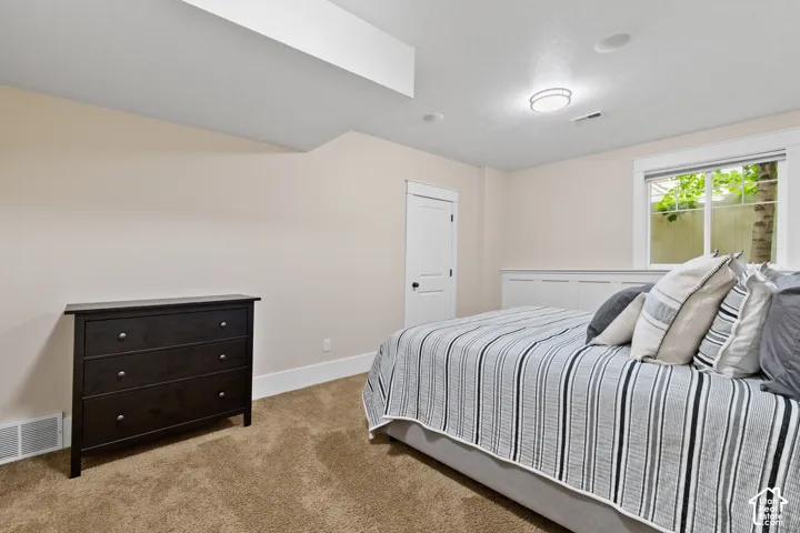 Neutral-toned interior featuring plush carpeting, custom built-in cabinetry, recessed lighting, and a multi-panel door