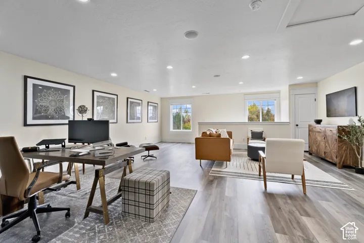 Open-concept space featuring wood-finish flooring, recessed lighting, and expansive windows