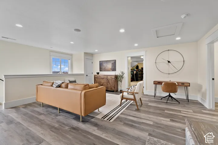 Open-concept room featuring wood-finish flooring, recessed lighting, and a partial partition wall