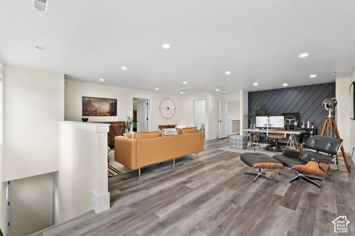 Open interior space featuring wood-finish flooring, recessed lighting, and a charcoal-toned diagonal shiplap accent wall