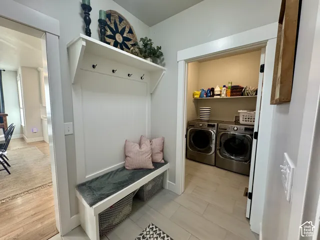 Built-in mudroom bench with beadboard paneling, upper shelving, and integrated coat hooks, complemented by tiled flooring and a dedicated laundry area with fixed shelving