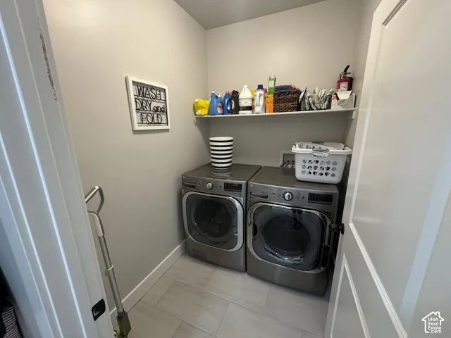 Dedicated utility area featuring rectangular tile flooring and a built-in overhead shelf