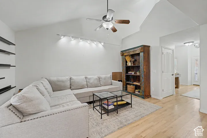 Vaulted ceiling, ceiling fan, wood-finish flooring, track lighting, built-in shelving