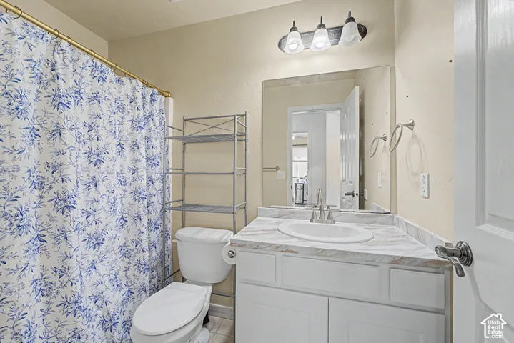 White vanity with a laminate countertop, undermount sink, and brushed nickel faucet